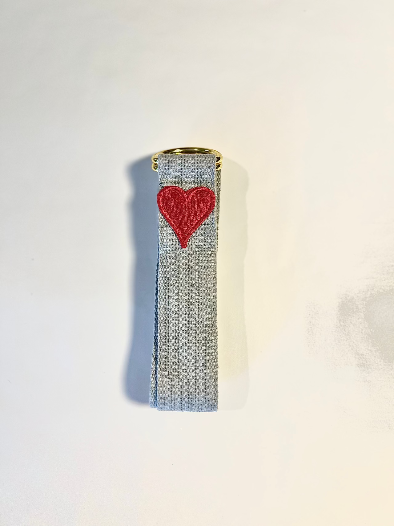 Rectangular object with a red heart design on a light gray background