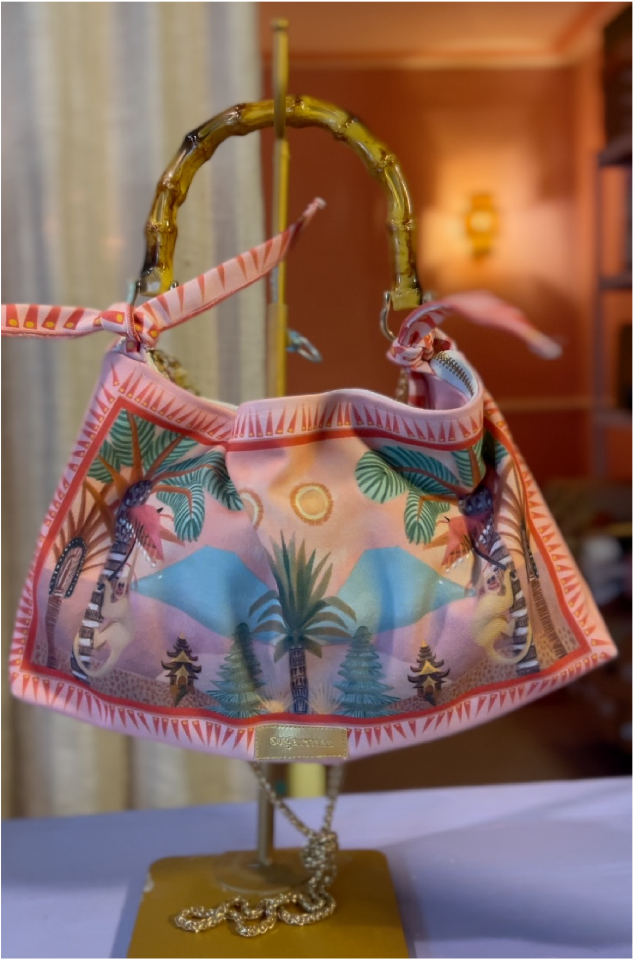 Colorful handbag with palm tree design on a stand