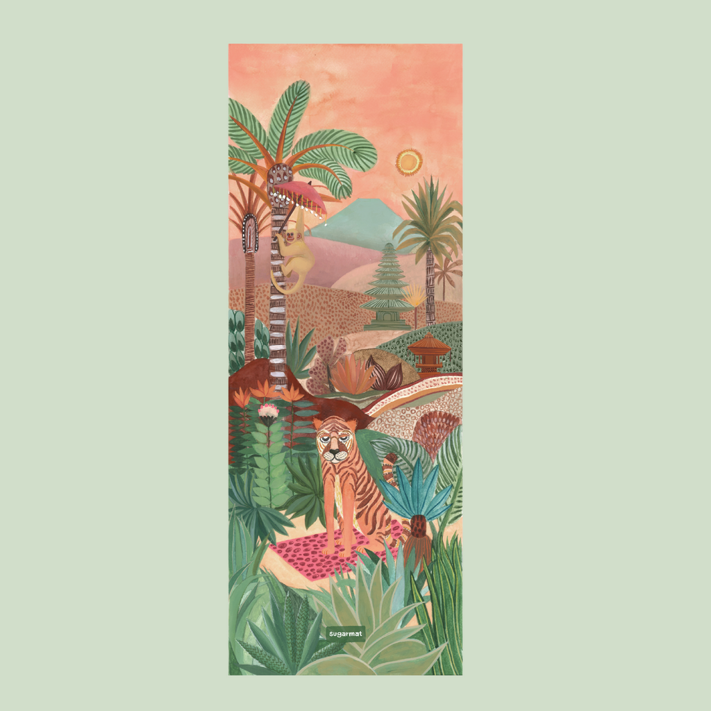 A yoga mat with a painted design featuring a landscape with palm trees, a sun, and a stylized tiger.