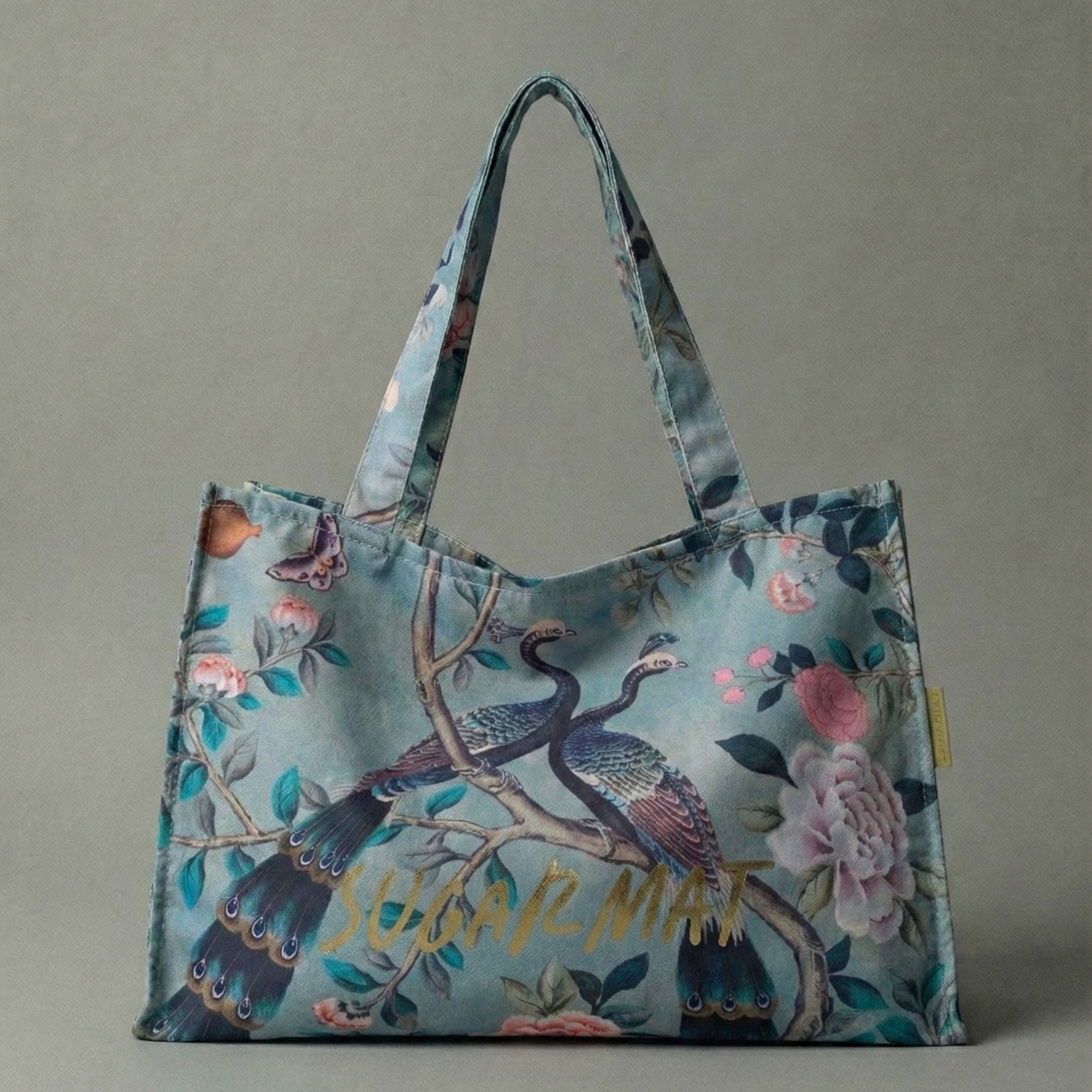 Floral and bird patterned tote bag with 'SUGAR MAT' text on a gray background
