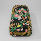 Floral and animal patterned makeup bag on a gray background