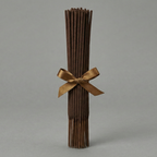 Bouquet of dried brown sticks tied with a gold ribbon on a gray background