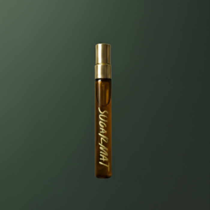 Small brown bottle with gold cap on a dark green background