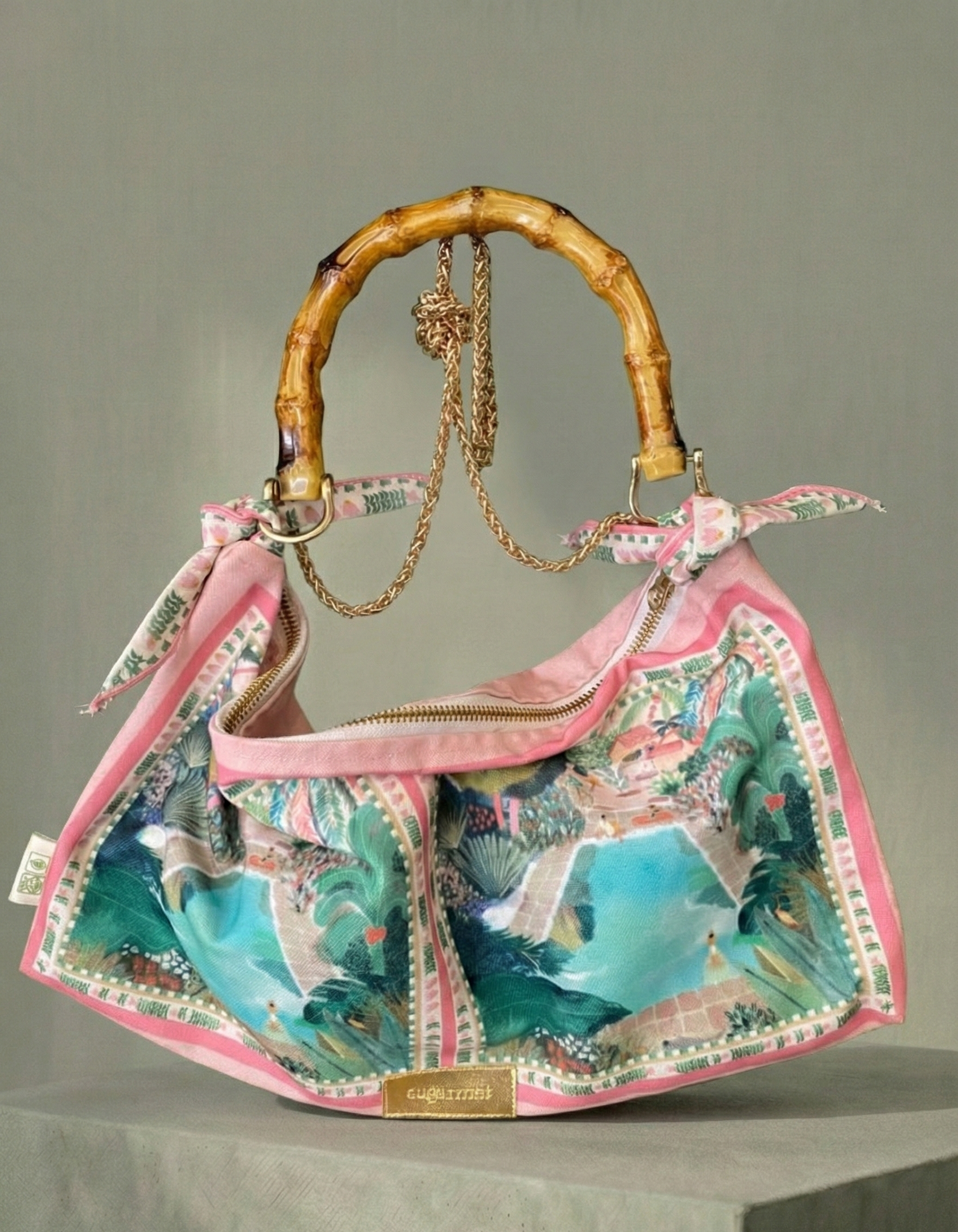 Colorful handbag with a decorative handle on a gray background