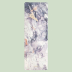 A suede yoga mat with abstract purple artwork, rolled up on a white background.