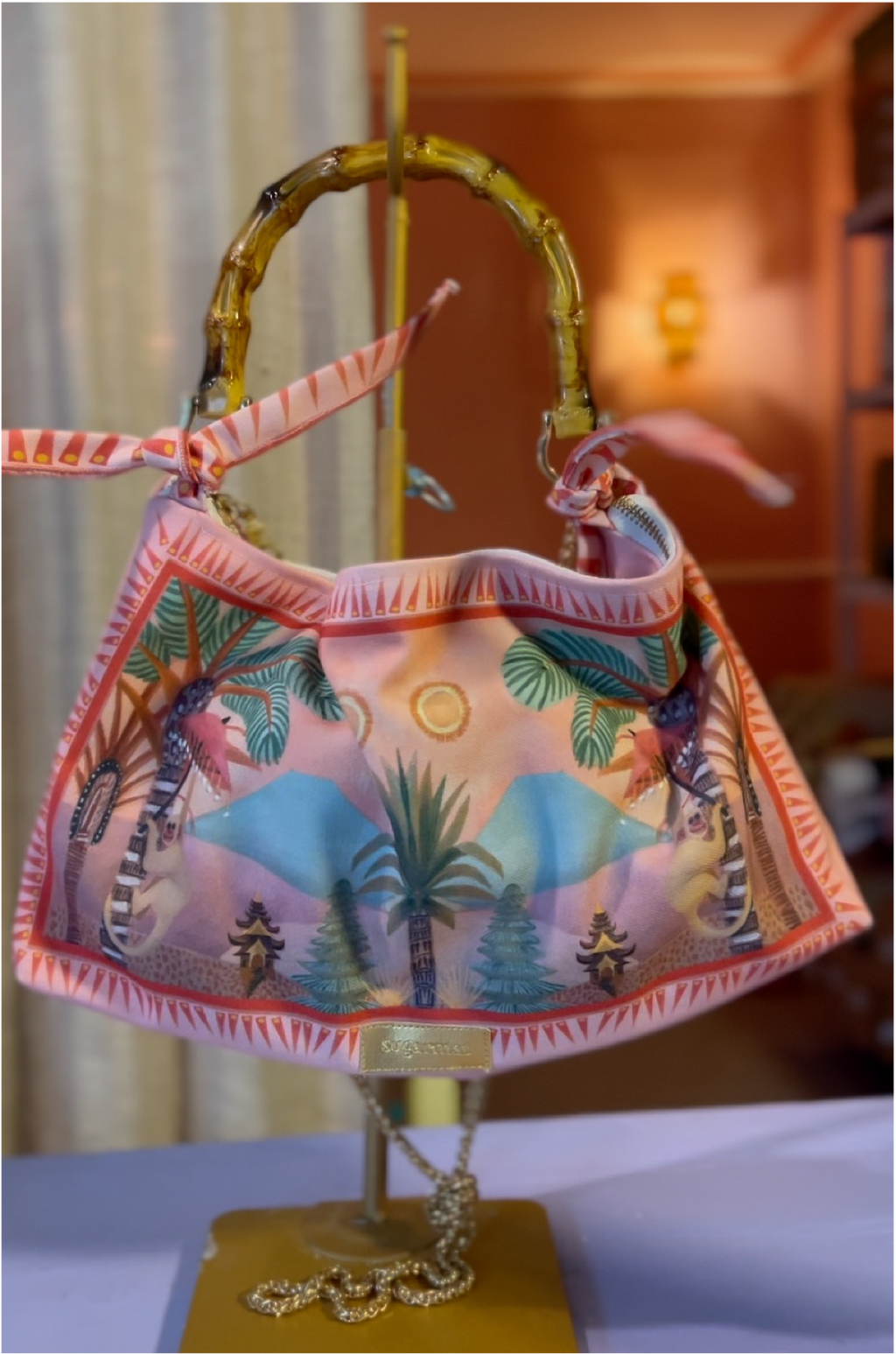 Colorful handbag with palm tree design on a stand